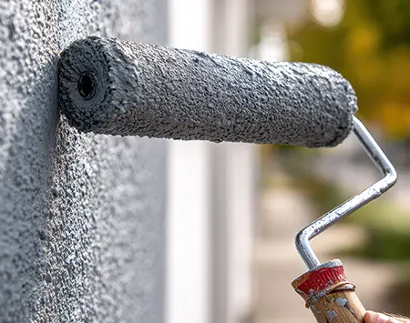 Rouleau de peinture contre un mur